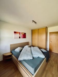 a bedroom with a large bed with blue sheets at Ski Apartmán Salomon in Loučná pod Klínovcem