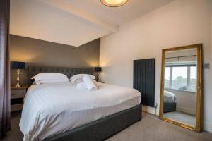 a bedroom with a large bed and a mirror at Apartment 3 Jester Court in Windermere