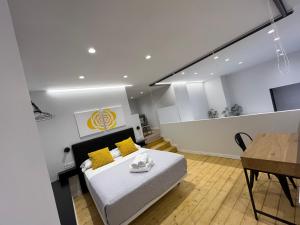 a bedroom with a bed with yellow pillows and a table at LOFT Accommodative A in Valencia