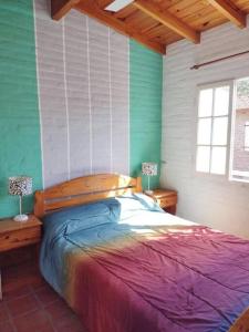 a bedroom with a bed with a wooden head board at Casita del Mar in Las Toninas