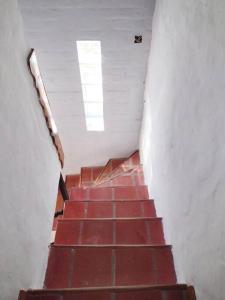 a staircase with a red tile floor and a window at Casita del Mar in Las Toninas +1 photo