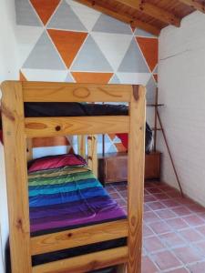 a wooden bunk bed in a room with a checkered wall at Casita del Mar in Las Toninas