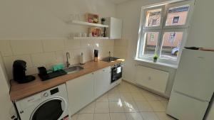 a kitchen with a sink and a washing machine at Aura - Nula #2 - 2 Zimmer, 4 Betten, Küche, Balkon, Waschmaschine in Merseburg