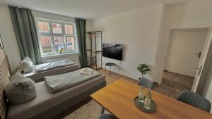 a living room with a couch and a table at Aura - Nula #2 - 2 Zimmer, 4 Betten, Küche, Balkon, Waschmaschine in Merseburg