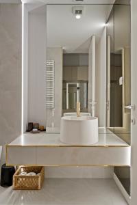 ein Badezimmer mit Waschbecken und Spiegel in der Unterkunft Apartament Luxury Cortina North Residence Pipera in Voluntari + 29 Fotos