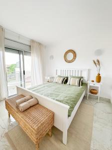 een witte slaapkamer met een groot bed en een rotan bank bij Luxury 3-BDR Families & Friends Villa Ocean View in Puerto de Santiago