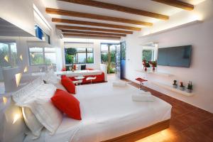 a bedroom with a large white bed with red pillows at Felix Residence in Mousata