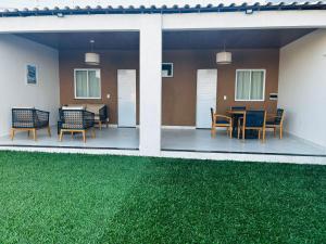 a patio with chairs and a table with green grass at Casa Refúgio em Tianguá in Tianguá +9 photos