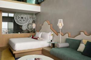 a hotel room with a bed and a couch at W Algarve in Albufeira
