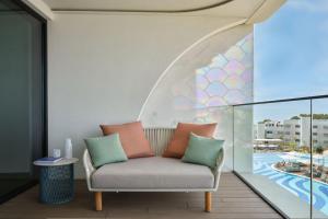 a couch with pillows on a balcony with a pool at W Algarve in Albufeira