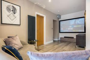 a living room with a couch and a flat screen tv at Apartment 2 Jester Court in Windermere