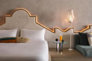 a bedroom with a white bed and a couch at W Algarve in Albufeira