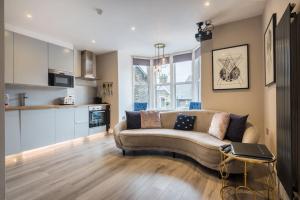 a living room with a couch and a kitchen at Apartment 2 Jester Court in Windermere