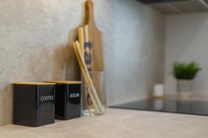 deux boîtes noires posées sur un comptoir à côté de baguettes dans l'établissement Apartamenty Falista Łódź Retkinia, à Łódź