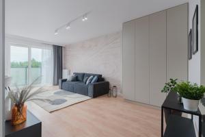 un salon avec un canapé bleu dans une pièce dans l'établissement Apartamenty Falista Łódź Retkinia, à Łódź