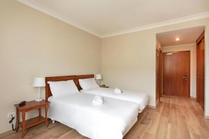 阿菲B&B Hotel Affi - Lago di Garda的一间卧室设有两张床、一张桌子和一扇门
