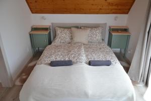 a bedroom with a white bed with two night stands at Kobra House in Orfű
