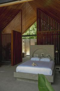 ein Schlafzimmer mit einem großen Bett in einem Zimmer mit Fenstern in der Unterkunft Karang Villas Uluwatu in Uluwatu