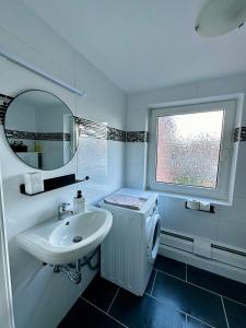 a white bathroom with a sink and a mirror at Casa Corina in Norden