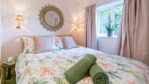 a bedroom with a bed and a mirror and a window at Ty Cadwgan in Aberffraw