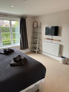 a bedroom with a bed and a flat screen tv at Luxury 5 bedroom house - sleeps 10 in Colkirk