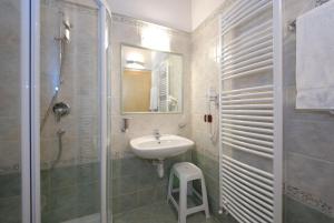 a bathroom with a sink and a shower with a mirror at Hotel L'Ideale in Moena