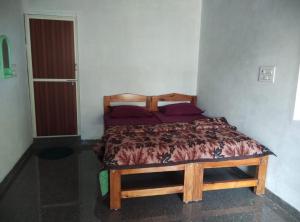 a bedroom with a wooden bed in a room at Gubbikanta Homestay in Aralagodu +10 photos
