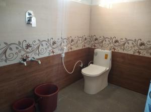 a bathroom with a toilet and a faucet at Gubbikanta Homestay in Aralagodu