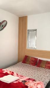 a bedroom with a bed with red pillows and a window at Minamo Homestay Modern Tengah Kota Payakumbuh in Payakumbuh