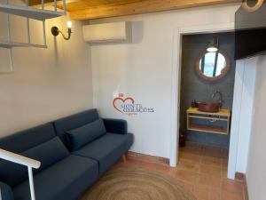 ein Wohnzimmer mit einer blauen Couch und einer Küche in der Unterkunft Monte Gerações - Complete House - Heated pool - Typical Algarvian - close to Quinta Lago Vale Lobo and Vilamoura in Almancil