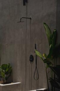 eine Dusche mit Duschkopf im Bad mit Pflanzen in der Unterkunft Karang Villas Uluwatu in Uluwatu + 12 Fotos