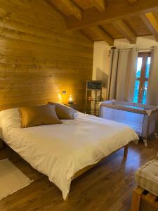 a large bed in a room with wooden walls at Ranch Enbrucà in Boves