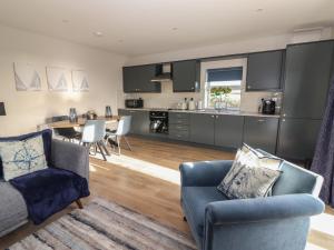 a kitchen and living room with a couch and chairs at The Boathouse in Kilkee