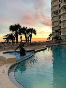 a person sitting on a bench next to a swimming pool at Beach Colony 18A in Pensacola