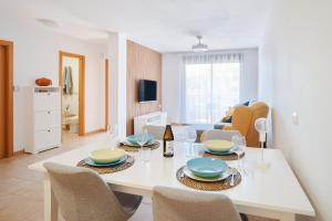 a dining room with a white table and chairs at Garden Suite in Granadilla de Abona +14 photos