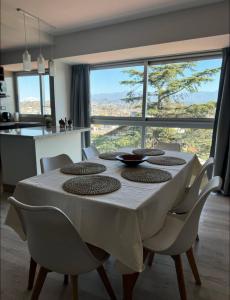 een eettafel met een wit tafelkleed en stoelen bij Excelente Dpto, Gran vista MDZ in Mendoza