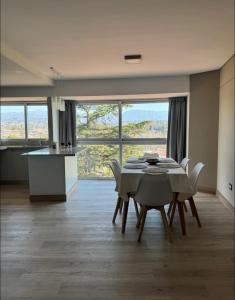 een eetkamer met een tafel en stoelen en een keuken bij Excelente Dpto, Gran vista MDZ in Mendoza