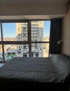 een slaapkamer met een bed en een groot raam bij Excelente Dpto, Gran vista MDZ in Mendoza +22 foto's
