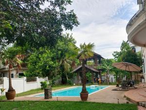 a resort with a swimming pool and an umbrella at VILLA SHAMIR in Sepang