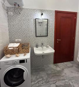 a bathroom with a washing machine and a sink at Lovely Guesthouse QSE in Quartu SantʼElena
