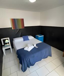 una camera da letto con un letto con due asciugamani e una sedia di Casa da Lua Buzios a Búzios