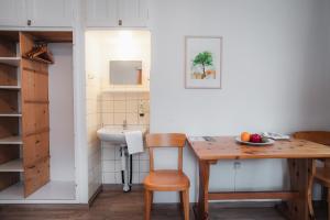 a small kitchen with a wooden table and a sink at B&B Haus Schönstatt contactless- Check-In in Brig