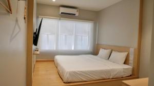 a bedroom with a white bed and a window at The Staytion Hotel at Sukhumvit in Amphoe Phra Khanong
