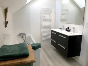 a white bathroom with a sink and a bath tub at Bruisse in Les Iffs +49 photos