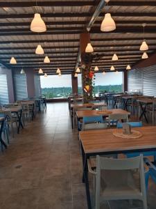 una sala da pranzo con tavoli, sedie e finestre di HOTEL NABU VALLEDUPAR a Valledupar