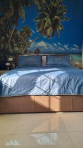 a bedroom with a bed with palm trees on the wall at La casa dell'artista in Ardea