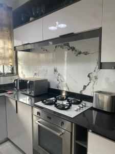a kitchen with a stove and a microwave at HA LUXURY TWO BEDROOMED Munyonyo in Gaba +10 photos