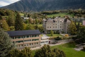 an aerial view of a building with mountains in the background at B&B Haus Schönstatt contactless- Check-In in Brig