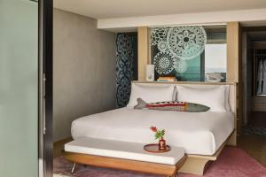 a bedroom with a white bed and a table at W Algarve in Albufeira