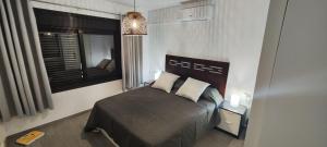 a bedroom with a black bed and a window at El Bungalow in Playa Fañabe +50 photos